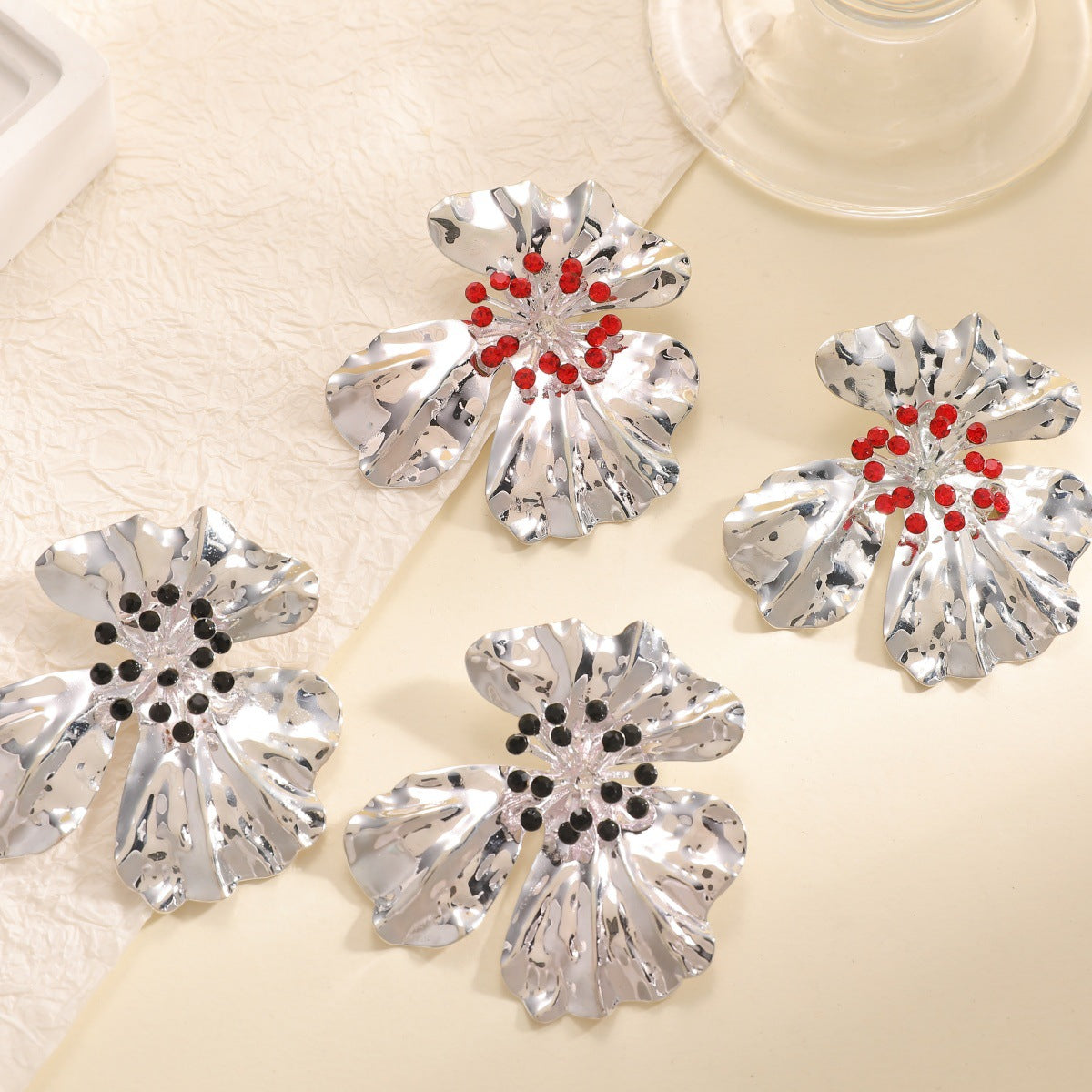 Women’s metal flower earrings with sparkling red accents
