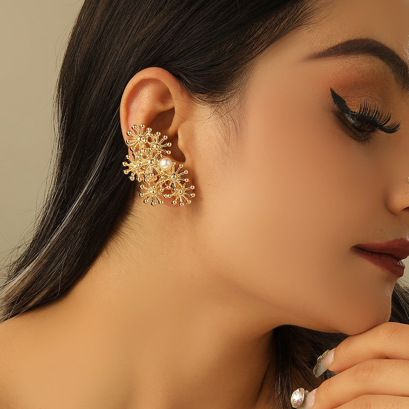 Women’s ear clips with elaborate flower design and pearl accent