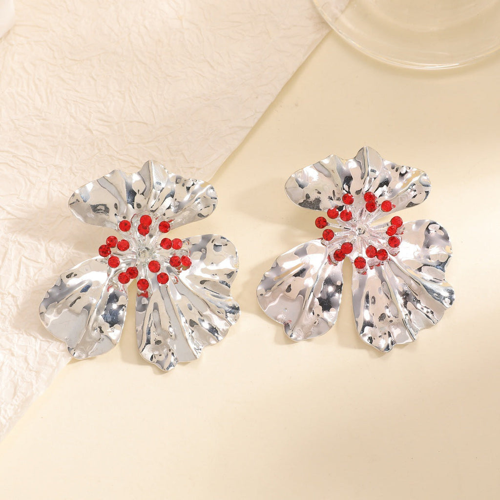 Women’s metal flower earrings with sparkling red accents