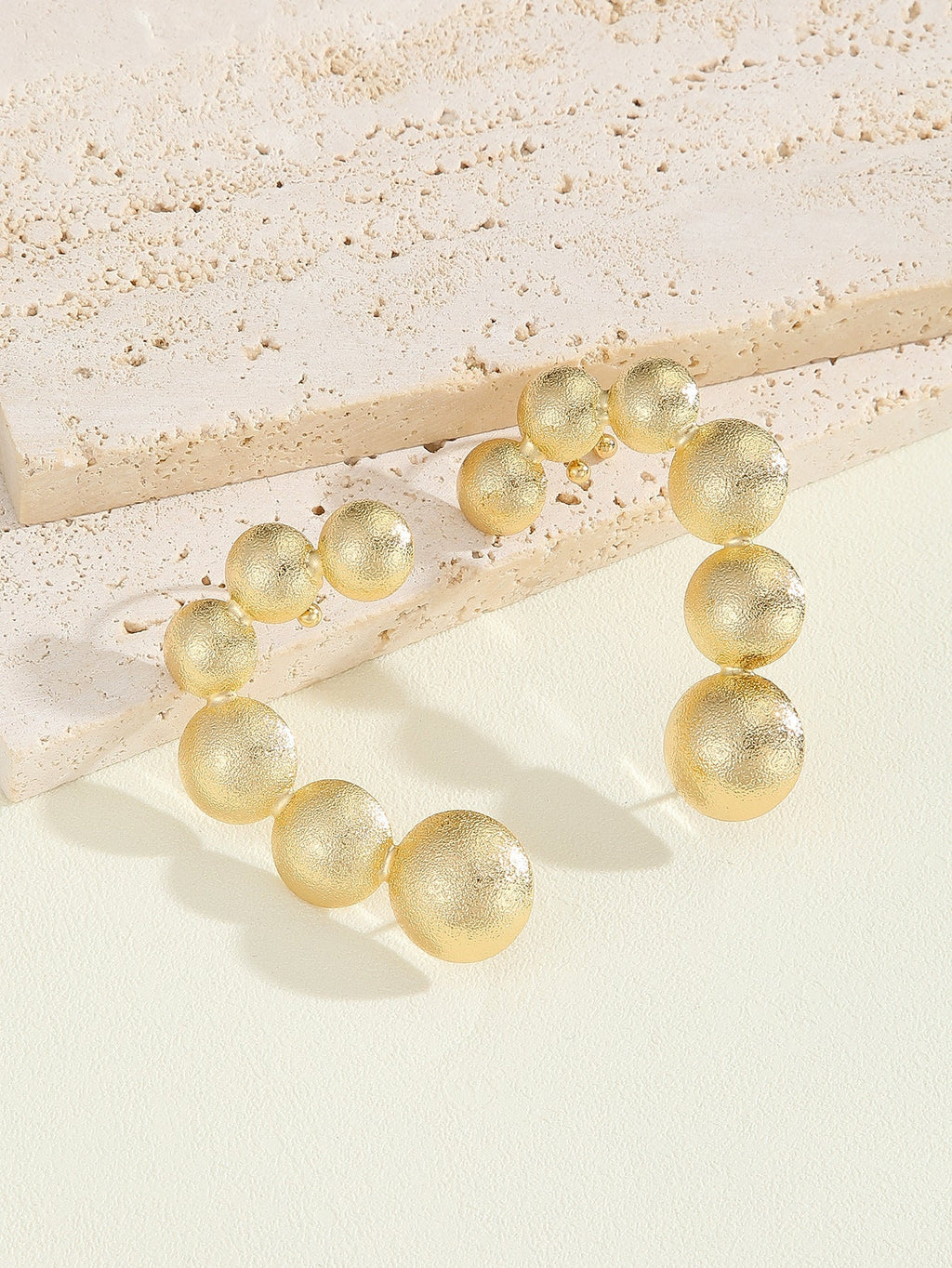 Women's bracelet with structured, golden beads