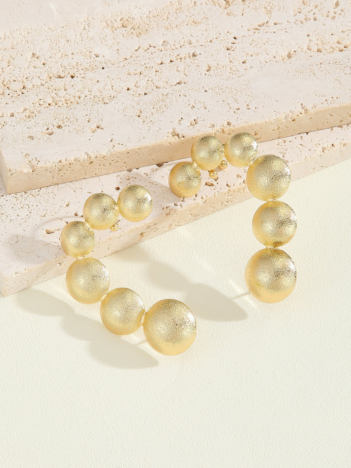 Women's bracelet with structured, golden beads