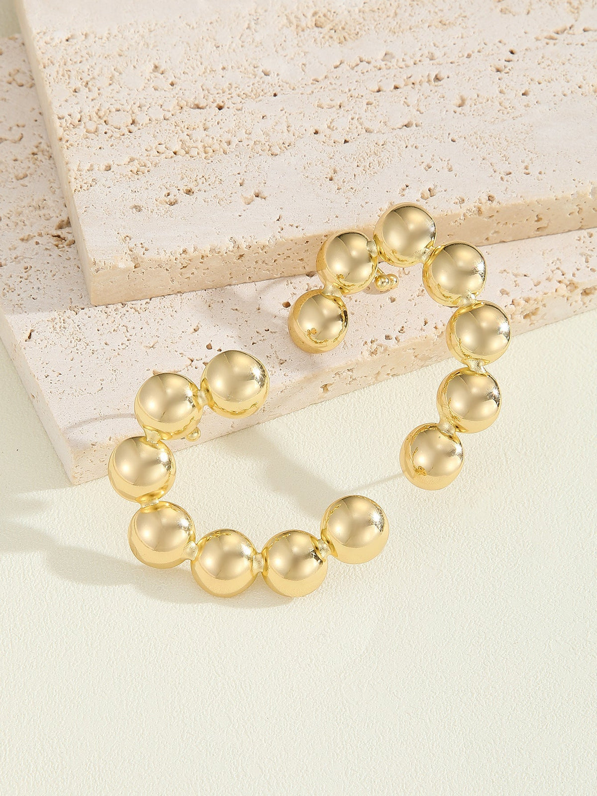 Women's bracelet with structured, golden beads