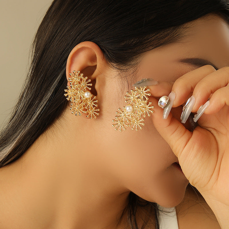 Women’s ear clips with elaborate flower design and pearl accent
