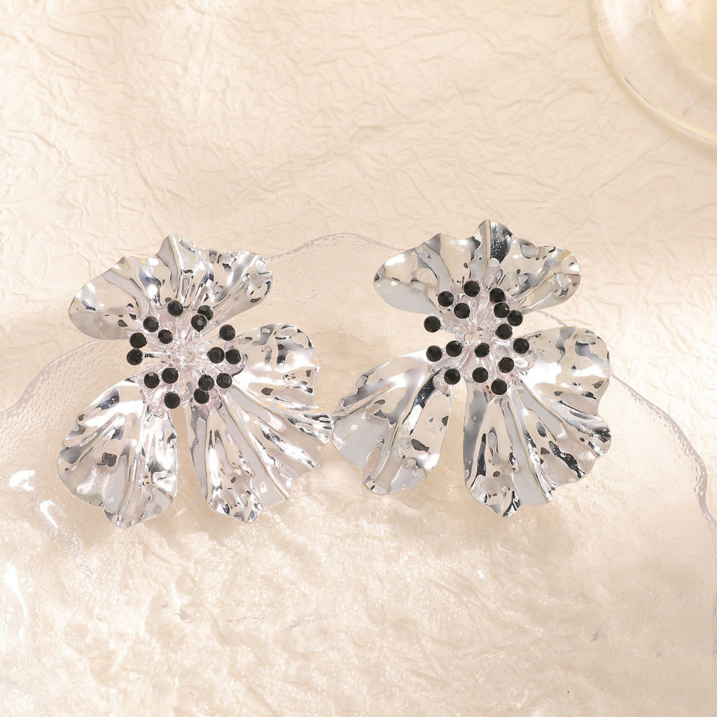 Women’s metal flower earrings with sparkling red accents
