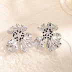 Women’s metal flower earrings with sparkling red accents