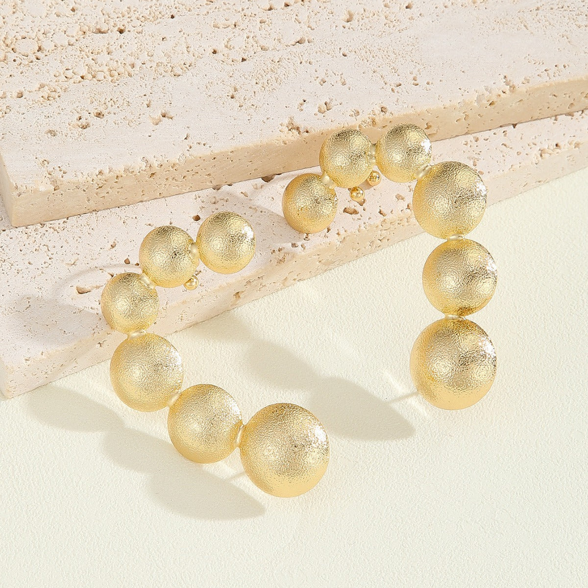 Women's bracelet with structured, golden beads