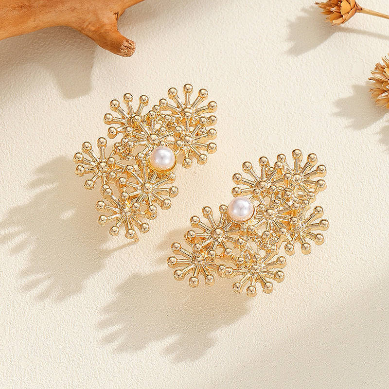 Women’s ear clips with elaborate flower design and pearl accent