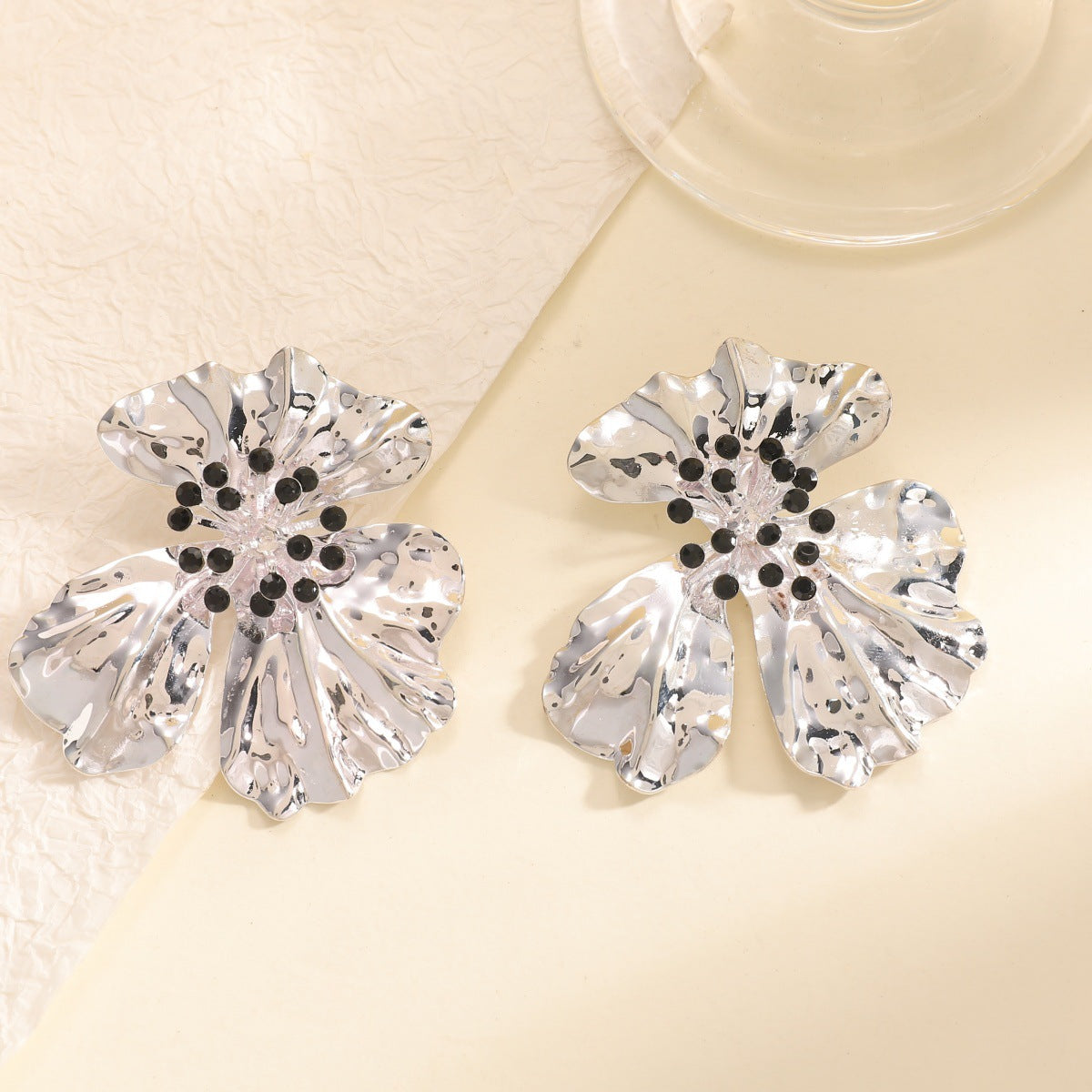 Women’s metal flower earrings with sparkling red accents