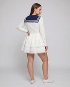 Women's nautical-inspired mini dress with wide skirt and continuous ruffle hem - back view