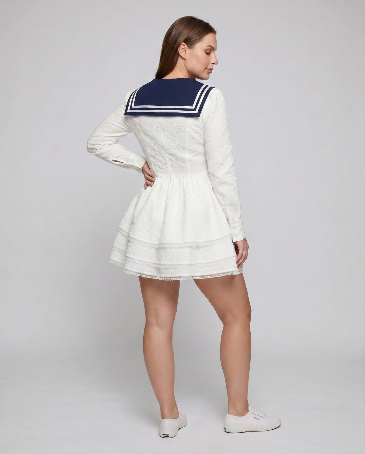 Women's nautical-inspired mini dress with wide skirt and continuous ruffle hem - back view