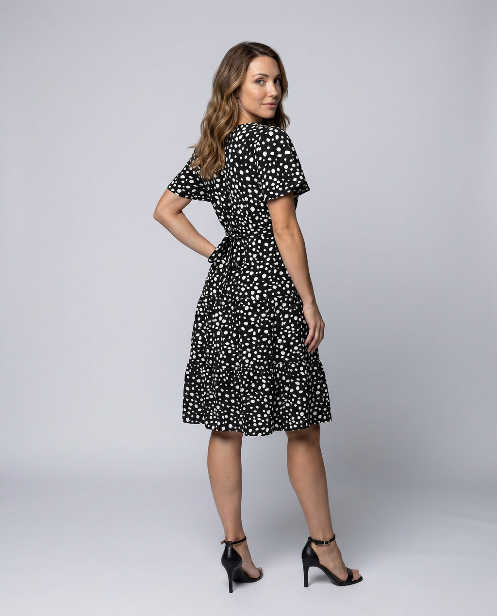 Women’s midi dress with flowing skirt and decorative polka dot pattern - back view