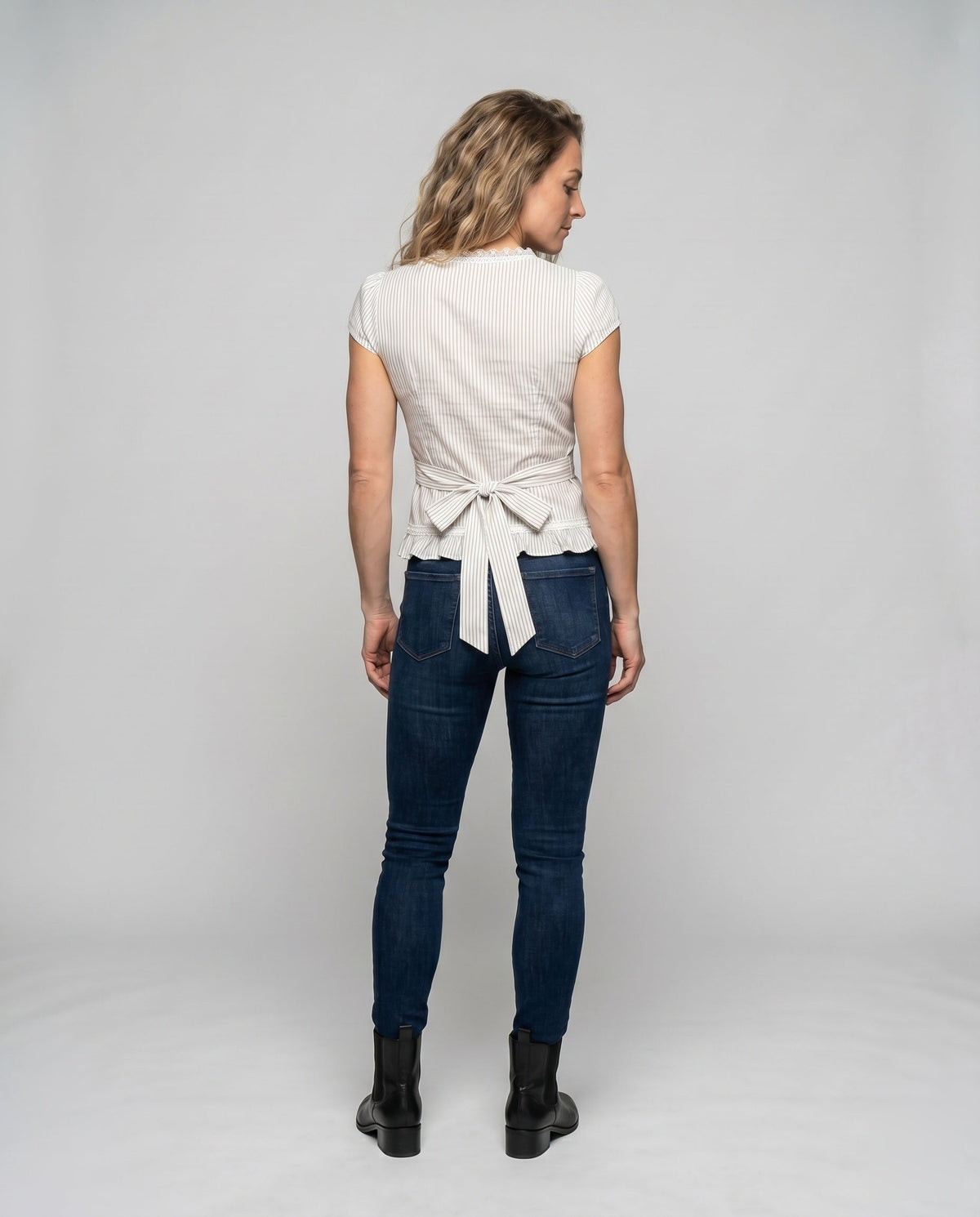 Women's blouse shirt with playful bow design and ruffle hem - back view
