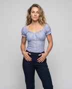 Women's fitted blouse top with ruffle details and button placket - upper body view