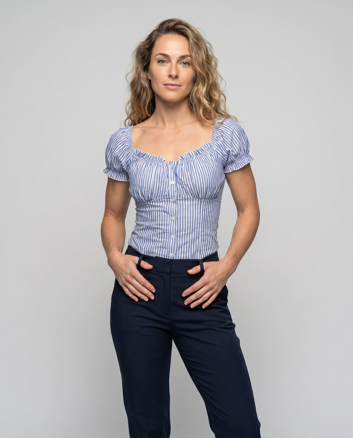 Women's fitted blouse top with ruffle details and button placket - upper body view